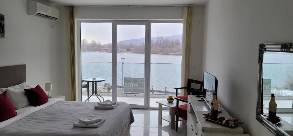 una camera da letto con un letto e una grande finestra di Apartmani MITIĆ a Veliko Gradište