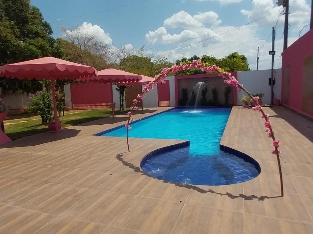 a pool with a girl standing in the middle of it at Family Space - Chacara Rosa Beautiful and Comfortable in Cuiabá