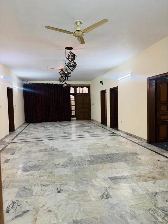 an empty room with a ceiling fan and a stone floor at Hotel living spot in Lahore