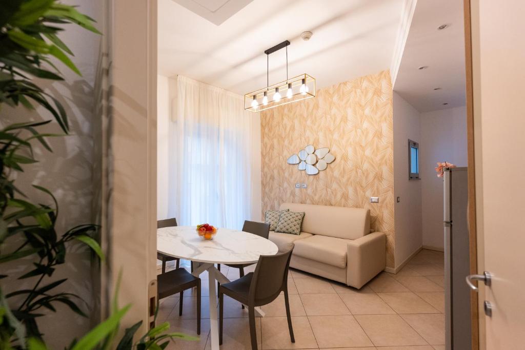 a dining room and living room with a table and a couch at Residence Perla in Misano Adriatico