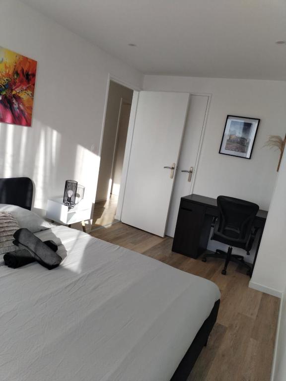 a bedroom with a bed and a desk and a chair at Superbe Appartement ! in Saint-Étienne