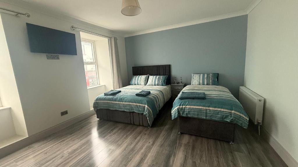 two beds sitting next to each other in a bedroom at Tipperary Town House in Tipperary