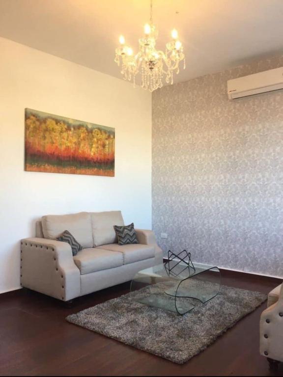 een woonkamer met een bank en een schilderij aan de muur bij Modern and centrally located apartment Self check-in in Guaymas