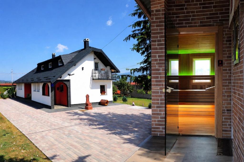 ein Haus mit einer Holztür neben einem Gebäude in der Unterkunft Relax Home ®Rajna® in Korenica