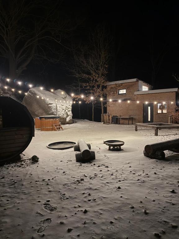 un parcheggio innevato di notte con luci di Kousek klidu pod skálou a Chrastava