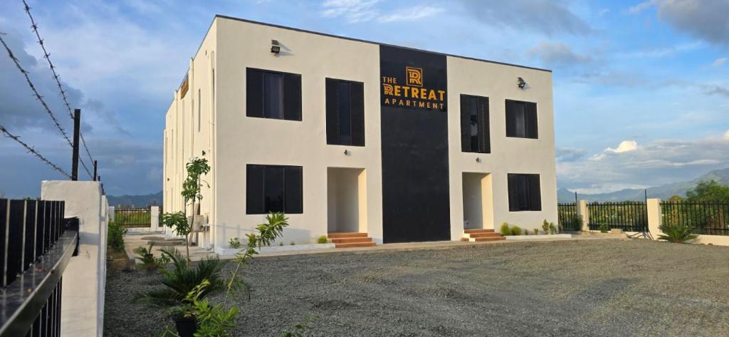 a white building with a black and yellow sign on it at The Retreat Apartment in Nadi