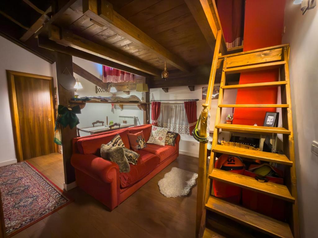 a living room with a red couch and a ladder at CasaVacanze Roccaraso in Roccaraso