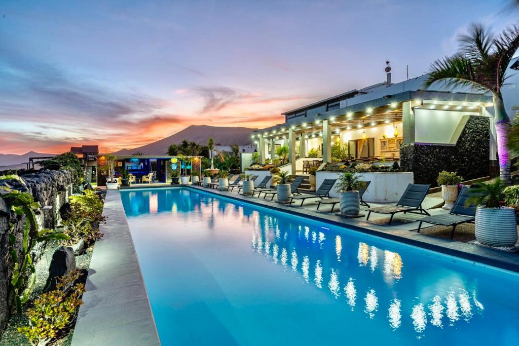 a swimming pool with chairs and a building at Exclusive SUPER-SIZE Holiday home - 12 bed,11 bath with Amazing Facilities, Sea and Mountain Views in Tías