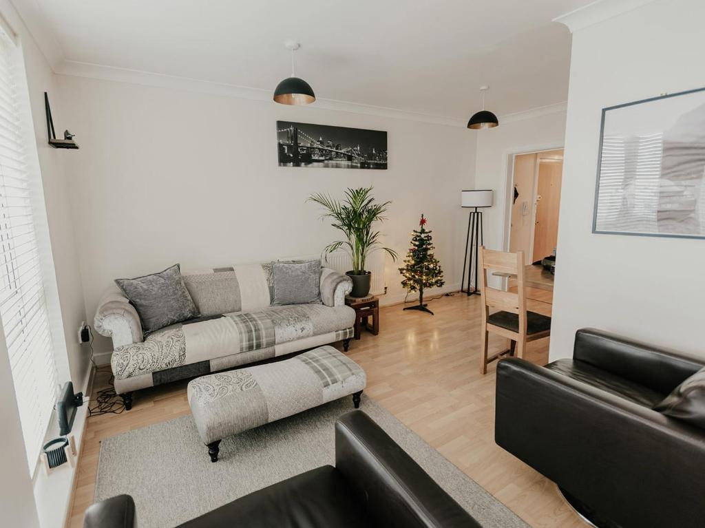 a living room with two couches and a christmas tree at 5 Mariners Wharf in Newhaven