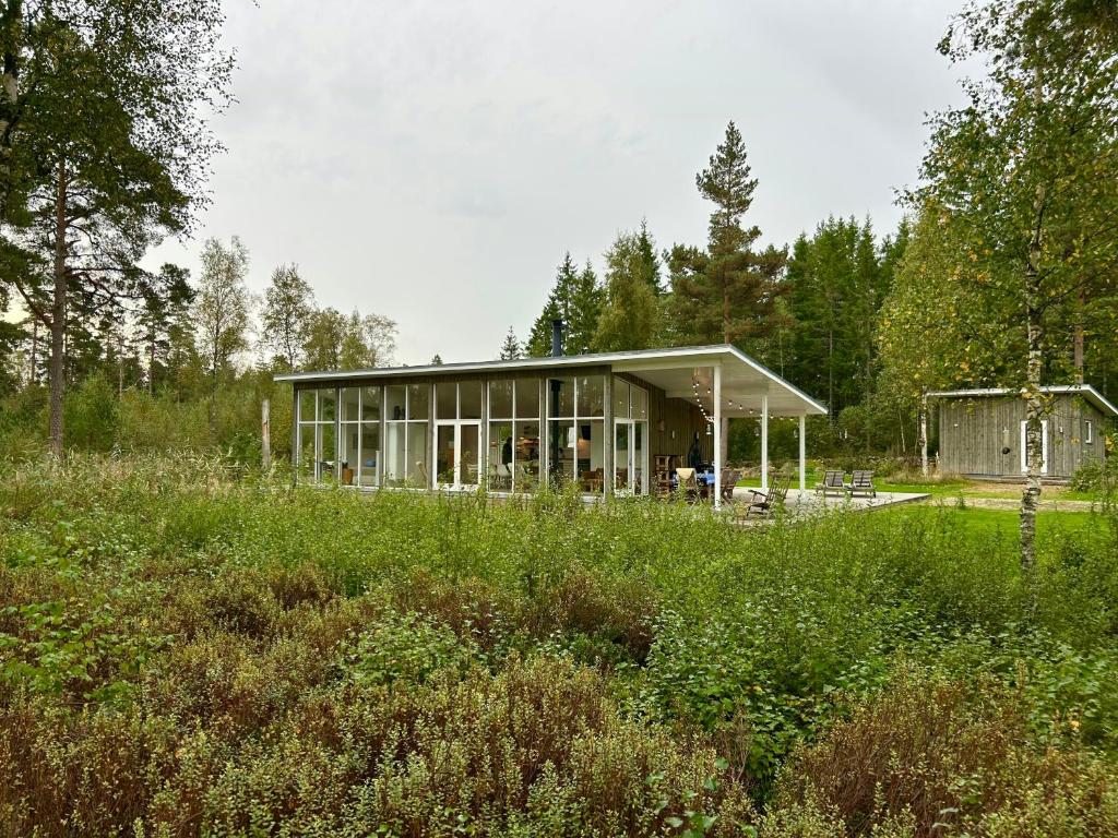 een huis midden in een veld bij Modern Peninsula Cabin With Panoramic View in Piggaboda