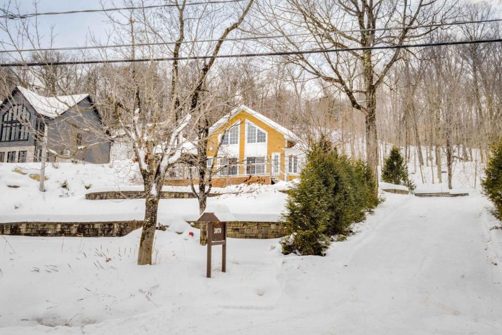 ein Haus in einem schneebedeckten Hof in der Unterkunft Spa Lake - Naturo lac Sept-Iles in Saint-Raymond