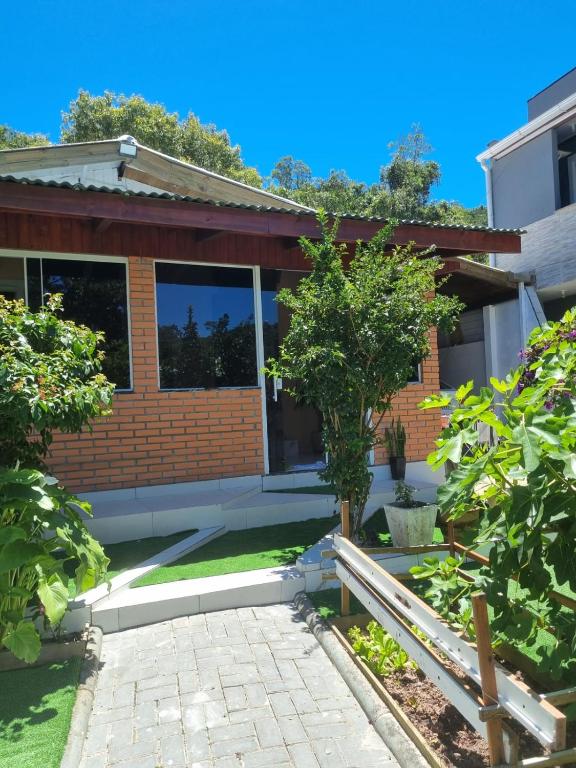 a brick house with a tree in the yard at Lugar Acolhedor e Próximo a Natureza in Florianópolis