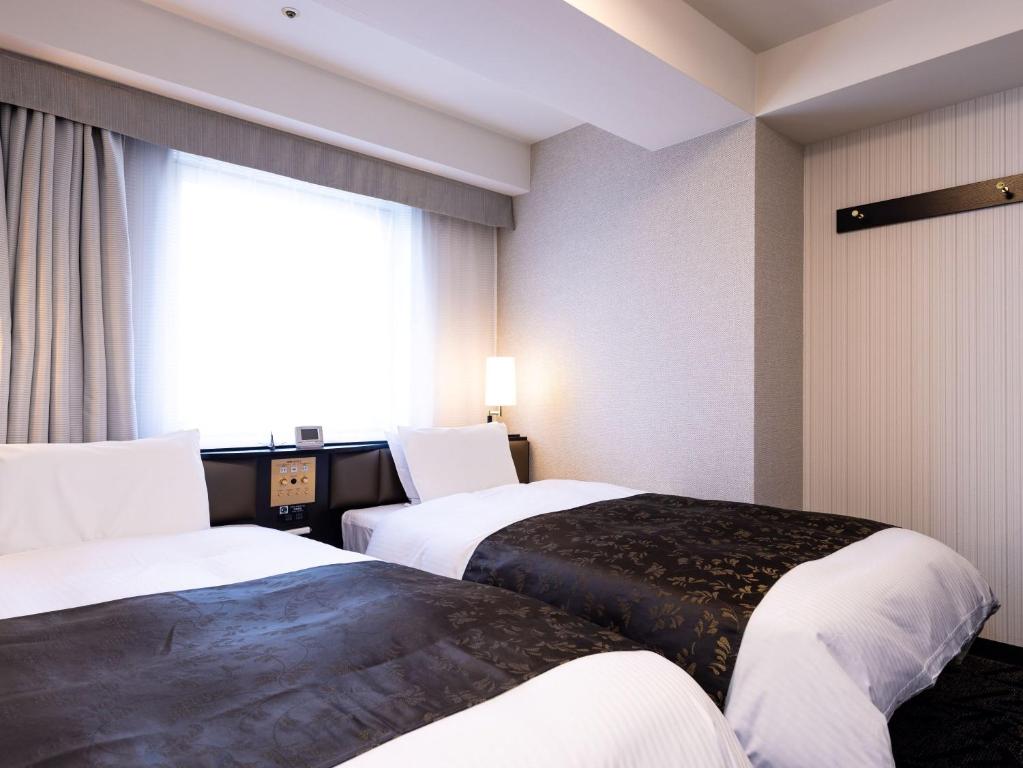 Postel nebo postele na pokoji v ubytování APA Hotel Fukui Katamachi