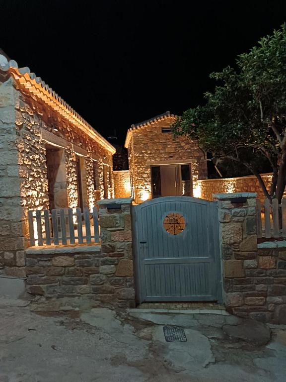 a house with a gate and a fence at night at petra apartments apartment No3 in Methoni