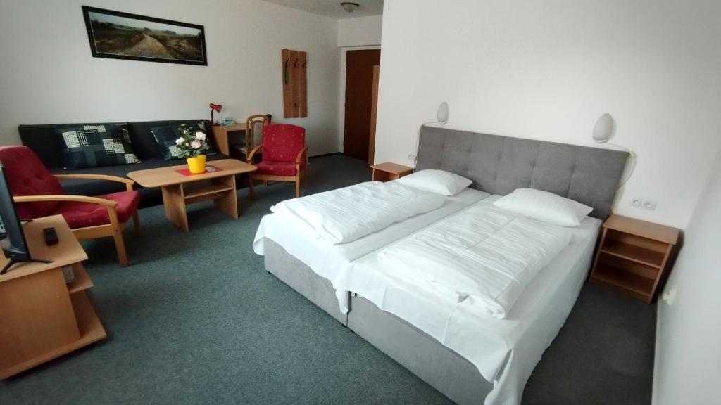 a bedroom with a large bed and a living room at Penzion U Pošty Blatná in Strakonice