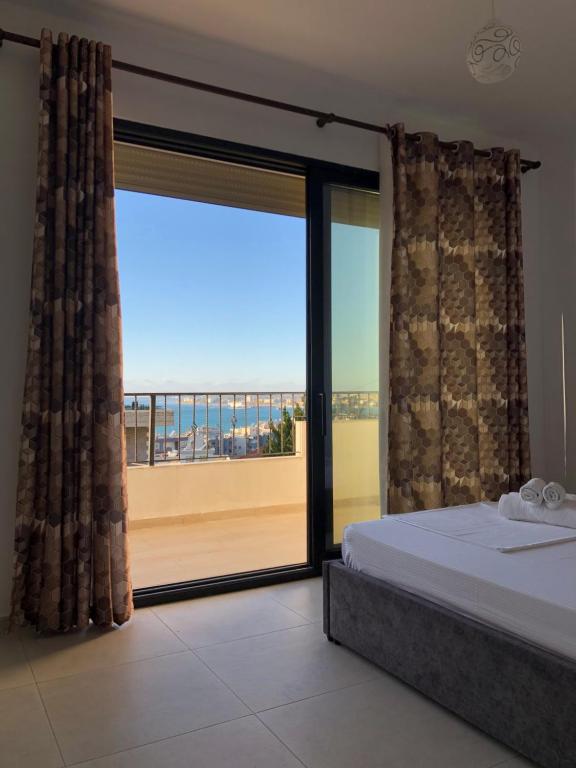 een slaapkamer met een bed en een groot glazen raam bij Actium in Vlorë