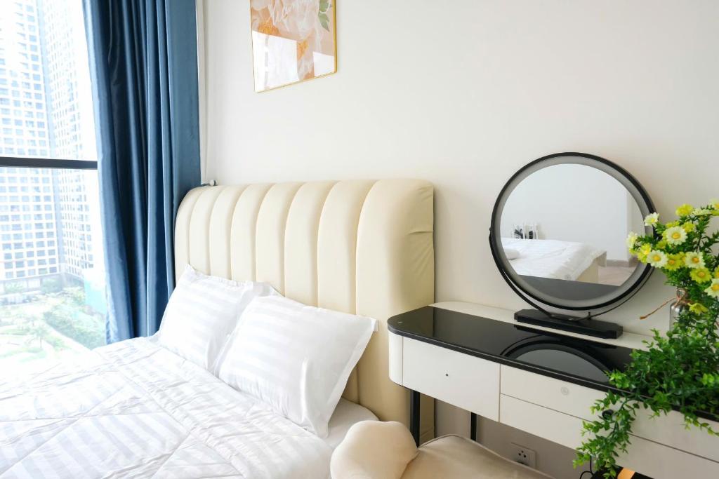 a bedroom with a bed and a mirror on a table at Tommy Land in Gò Công