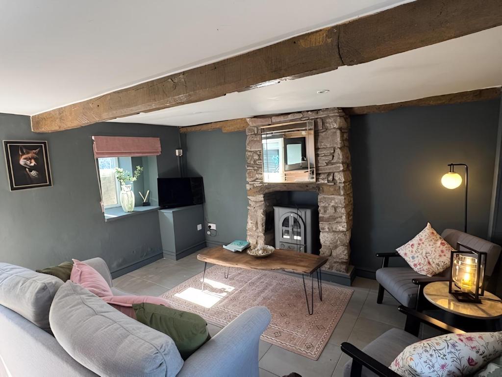 a living room with a couch and a fireplace at Ty Llaeth in Llanstephan