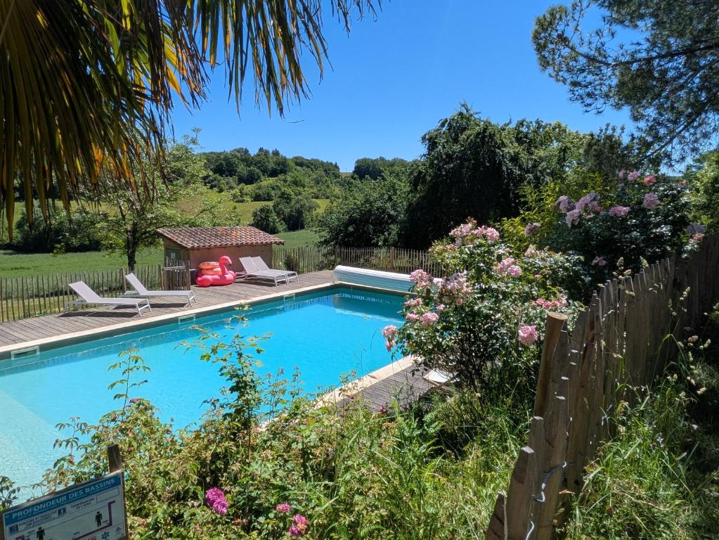 a swimming pool in a garden with chairs and flowers at Domaine de Calabel in Pouylebon