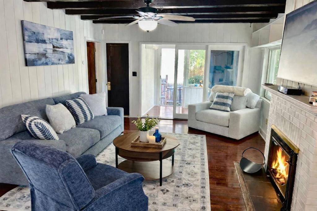 een woonkamer met een bank en een open haard bij Cherry Blossom Lake House in Lake Peekskill
