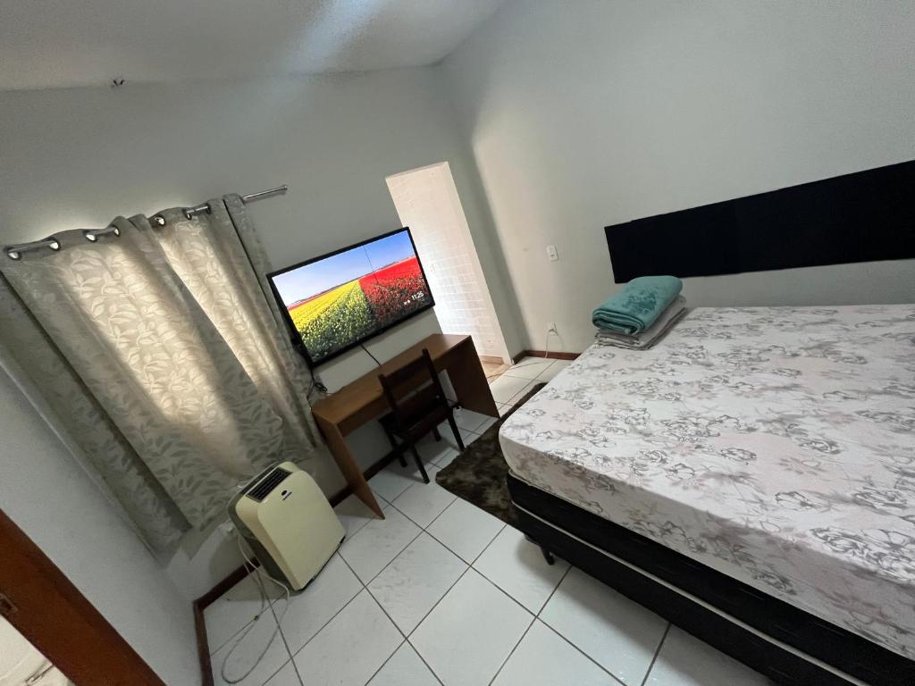 En eller flere senge i et værelse på Suíte Aconchegante