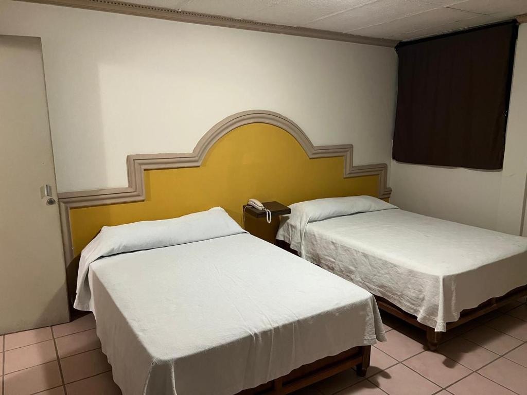 een kamer met twee bedden in een kamer bij Hotel y Restaurant Real Plaza Jacona in Ciudad Valles