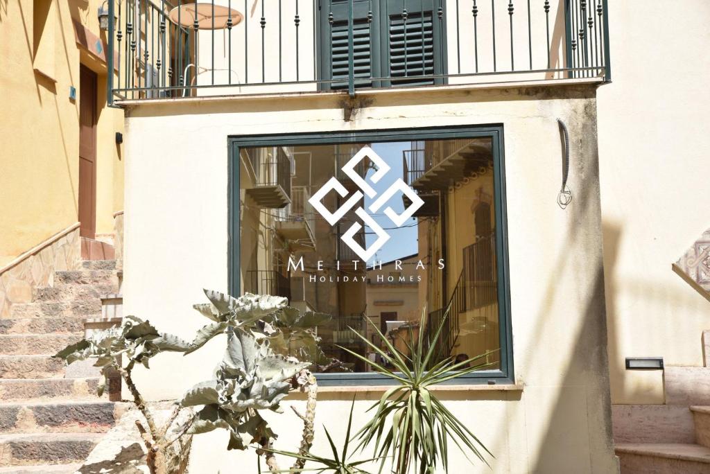 a window of a store with a sign in it at Meithras Holiday Homes in Agrigento