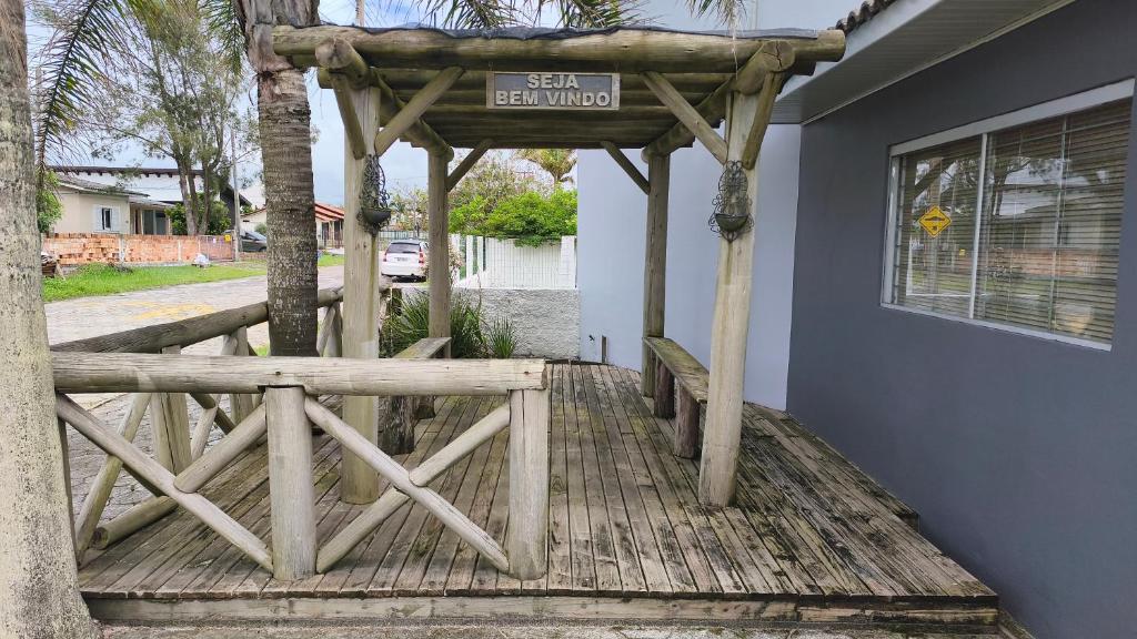 een veranda met een prieel met een bord erop bij Pousada Emanuel in Araranguá