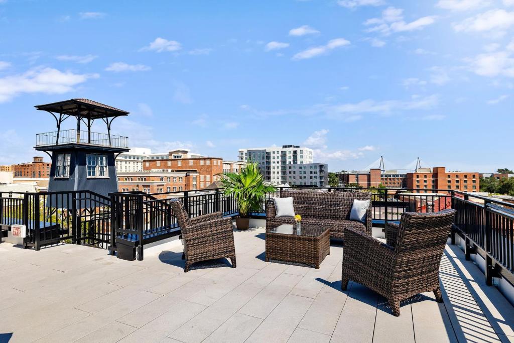 a patio with chairs and a gazebo on a roof at Fire Tower Downtown Gem 1BR with Balcony & Views in Charleston