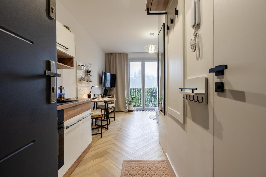 a kitchen with white cabinets and a table with chairs at Silverka Studio in Tarnowskie Góry