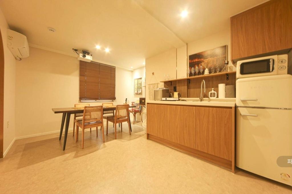 a kitchen and dining room with a table and a refrigerator at 인천청라점 이상한스테이 