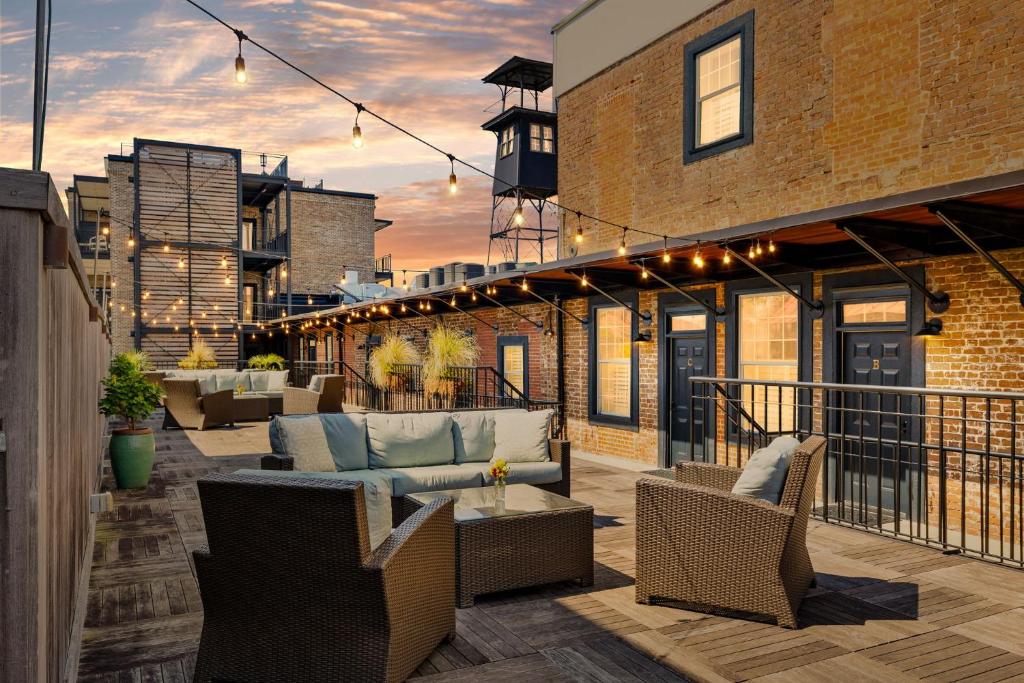 a patio with couches and chairs on a balcony at Perfect Location - King Street Condo in Charleston