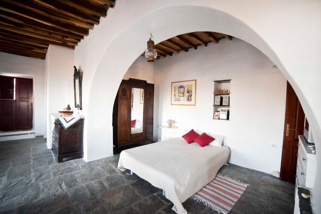 een slaapkamer met een wit bed met rode kussens bij Liotrivi, traditional house in Apollonia