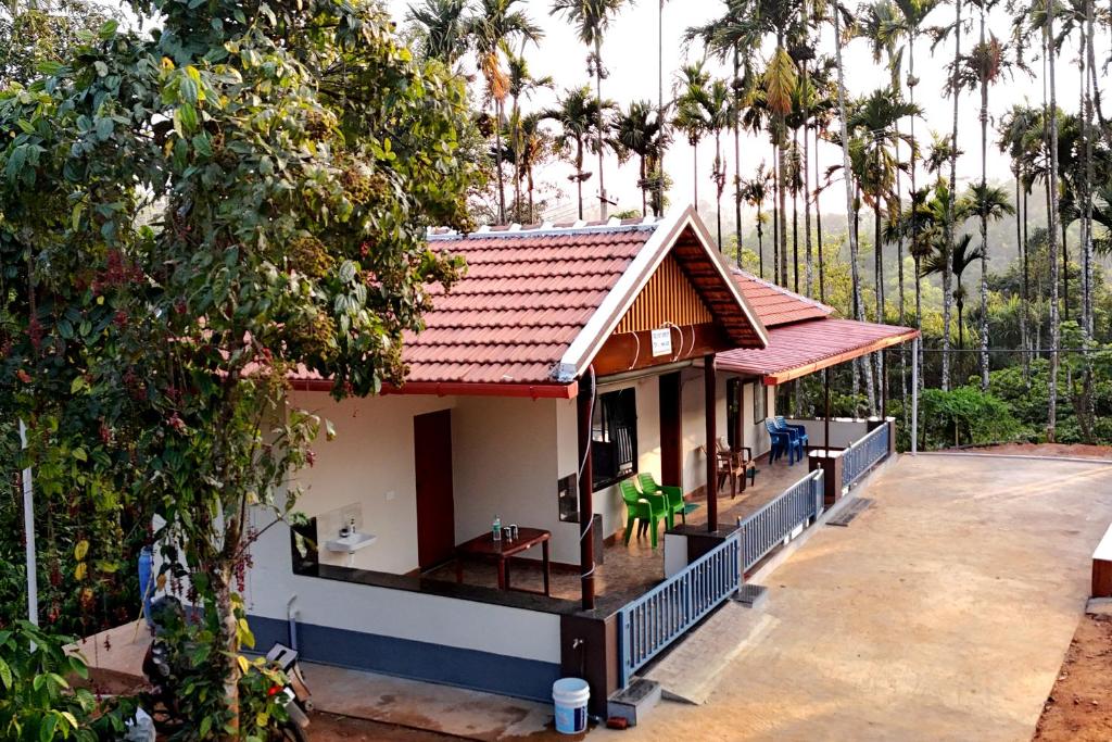 a small house with a red roof at Areca Nut Homestay in Mudigere