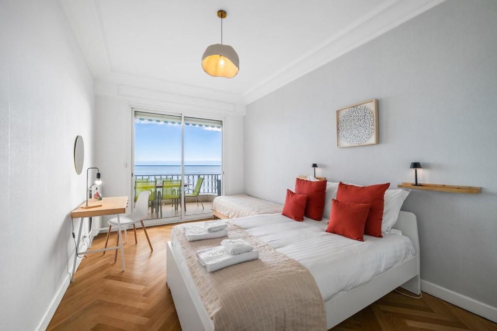 a bedroom with a large bed with red pillows at Le COQ Livieri - AC- WiFi - Seafront - town centre in Menton