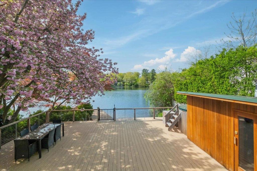 a wooden walkway with benches and a lake at Cherry Blossom Lake House in Lake Peekskill
