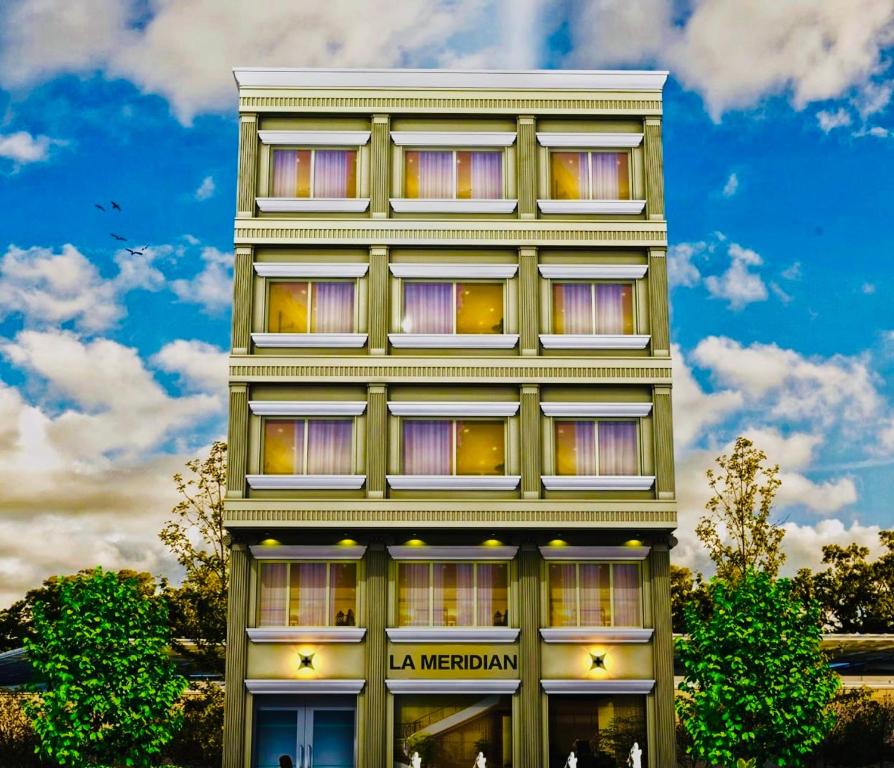 a tall building with windows on the side of it at Hotel The Meridian, Haridwar in Haridwār