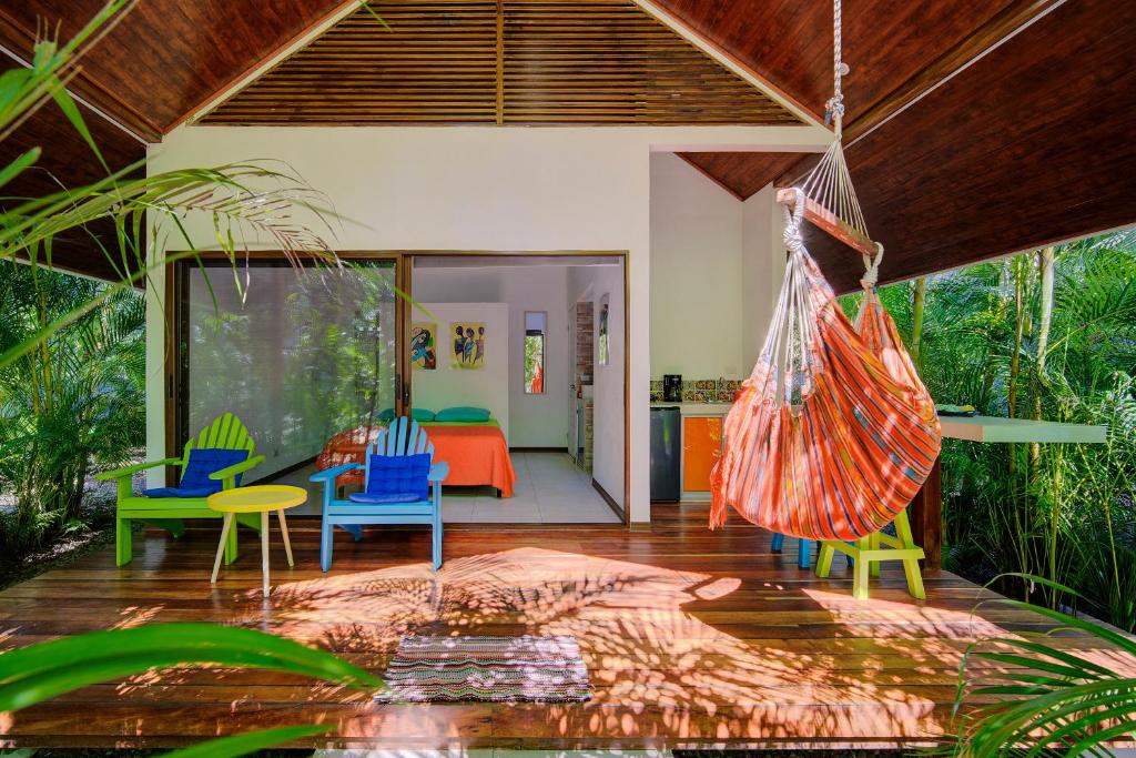 un soggiorno aperto con sedie colorate e un'amaca di Villa Wolaba a Puerto Viejo
