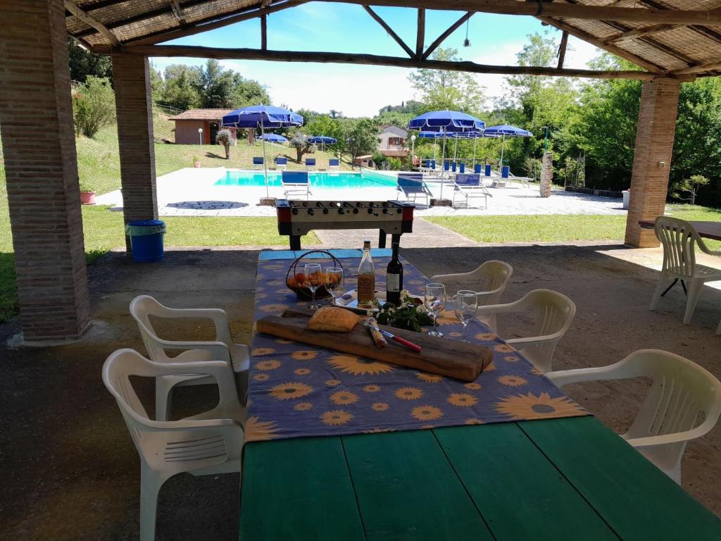 a table and chairs with a table and a pool at Apartment Jasmin by Interhome in Fauglia
