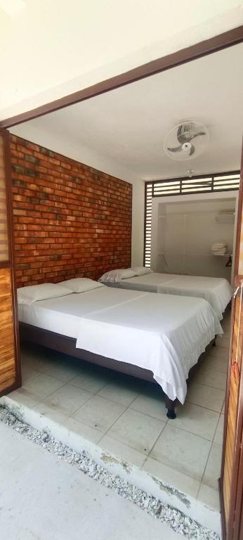a large bed in a room with a brick wall at Villa campestre Eagle in Girardot