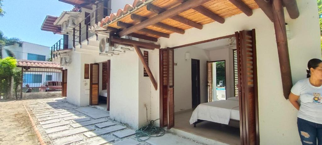 Un uomo in piedi di fronte a una casa di Villa campestre Eagle a Girardot