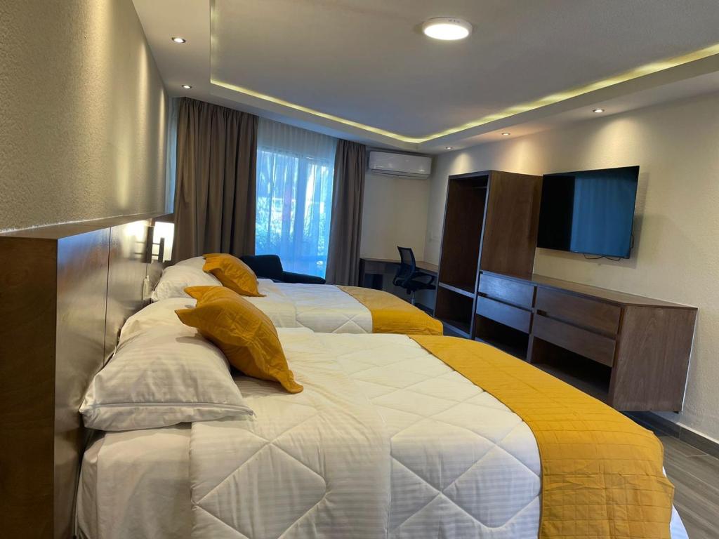 een hotelkamer met twee bedden en een televisie bij Hotel Imperial Saltillo in Saltillo