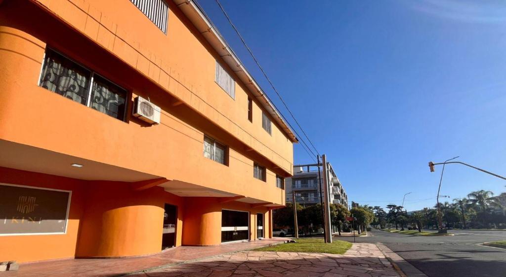 een oranje gebouw aan de straatkant bij KIN Hotel in Villa Carlos Paz