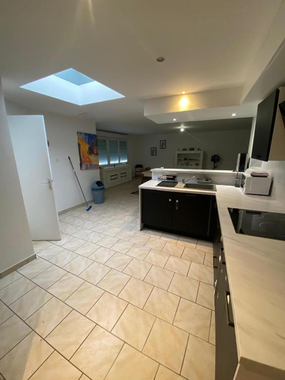 een grote keuken met een grote tegelvloer bij Le Glatigny in Le Havre