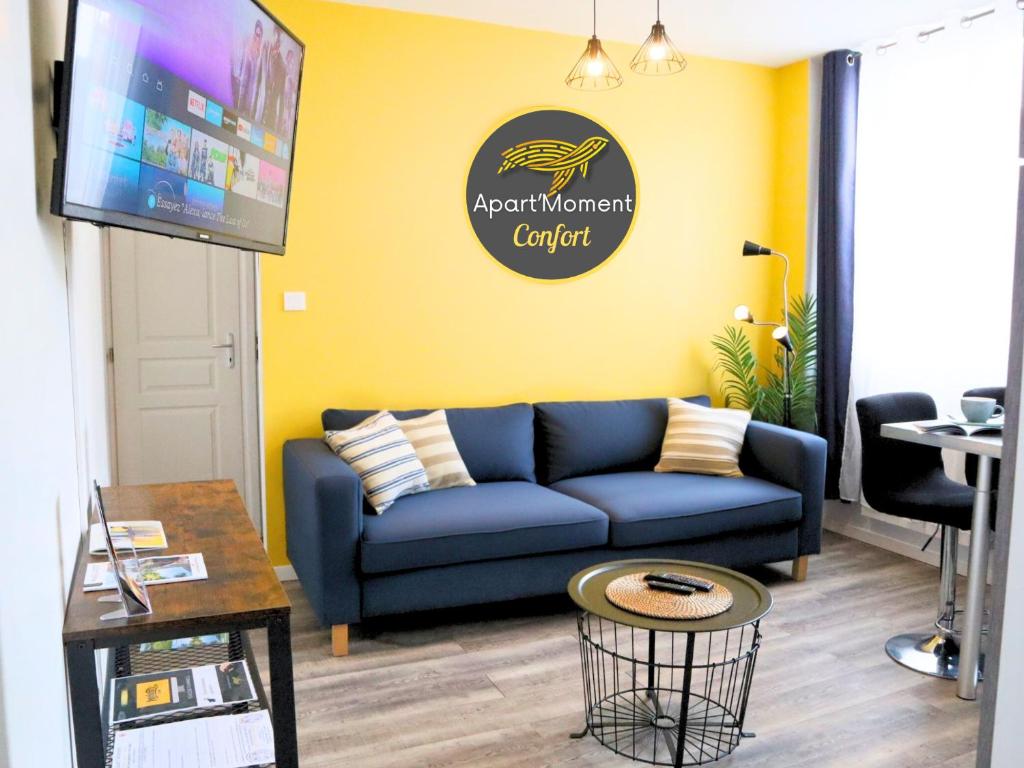 un soggiorno con un divano blu e una TV di Appartement Centre Saint-Omer, Parking privé gratuit a Saint-Omer