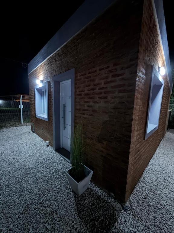 eine Ziegelwand mit einer Pflanze in einem Topf neben einer Tür in der Unterkunft Freedom in Miramar