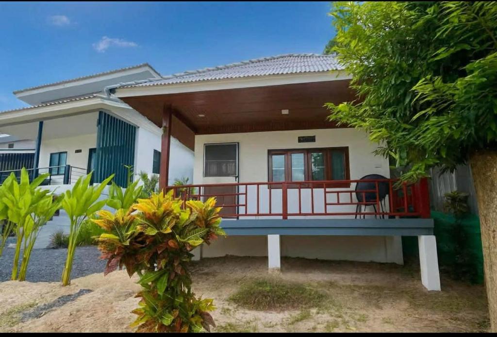 a house with a balcony in front of it at Wanderlust Cove in Wok Tum