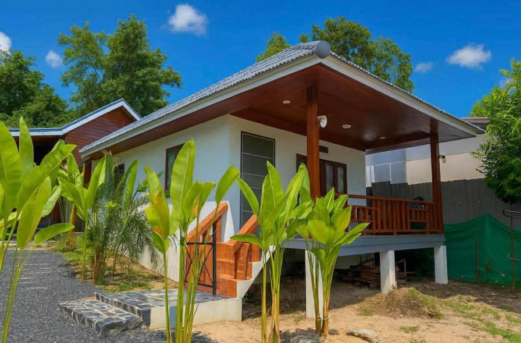 a house with a porch with a roof at Wanderlust Cove in Wok Tum