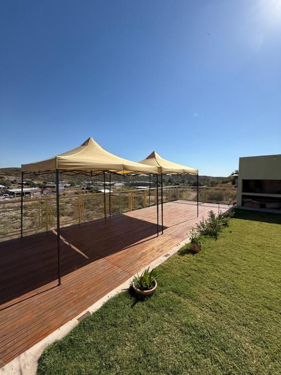 een terras met een beige parasol op een vlonder bij El Cerrito in Las Heras