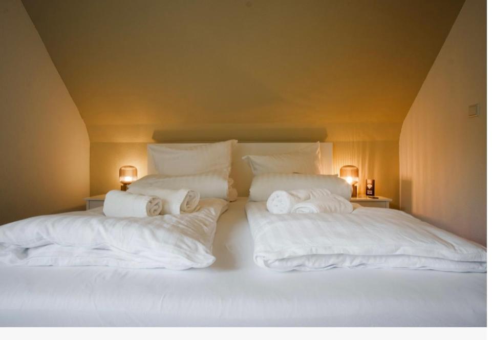 una camera con 2 letti con lenzuola e cuscini bianchi di Rhein Lahn Hotel a Lahnstein